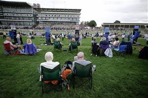 YORK, ENGLAND - AUGUST 23: Racegoers relax in the