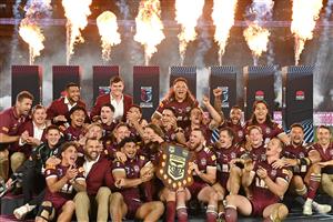 TOPSHOT - Maroons players celebrate with their trophy after winning the men