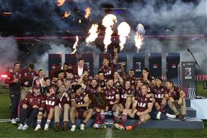 SYDNEY, AUSTRALIA - JULY 09: Maroons players and staff celebrate with the State of Origin Shield after winning game three of the Men