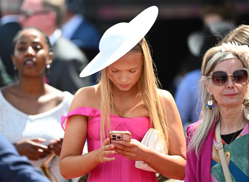 MELBOURNE, AUSTRALIA - OCTOBER 11: General view of racegoers on mobile phone during Melbourne Racing at Caulfield Racecourse on October 11, 2025 in Melbourne, Australia. (Photo by Vince Caligiuri/Getty Images)