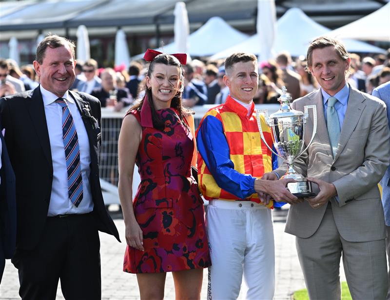 MELBOURNE, AUSTRALIA - OCTOBER 11: Damian Lane holds the trophy with Charlie Duckworth alongside partner Bonnie Lane and new MRC Chairman Cameron Fisher (L) after riding Autumn Boy after winning Race 8, the Sportsbet Caulfield Guineas during Melbourne Racing at Caulfield Racecourse on October 11, 2025 in Melbourne, Australia. (Photo by Vince Caligiuri/Getty Images)