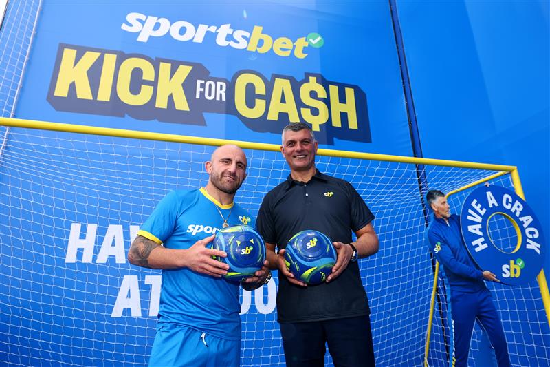 MELBOURNE, AUSTRALIA - OCTOBER 11: UFC fighter Alexander Volkanovski and John Aloisi pose during the Sportsbet Kick for Cash event at Caulfield Racecourse, celebrating the 20th anniversary of John Aloisi kicking the winning penalty that qualified Australia for the 2006 World Cup. (Getty)