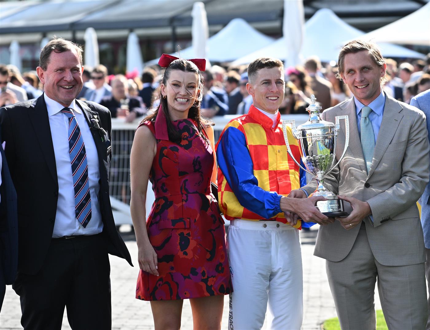 MELBOURNE, AUSTRALIA - OCTOBER 11: Damian Lane holds the trophy with Charlie Duckworth alongside partner Bonnie Lane and new MRC Chairman Cameron Fisher (L) after riding Autumn Boy after winning Race 8, the Sportsbet Caulfield Guineas during Melbourne Racing at Caulfield Racecourse on October 11, 2025 in Melbourne, Australia. (Photo by Vince Caligiuri/Getty Images)
