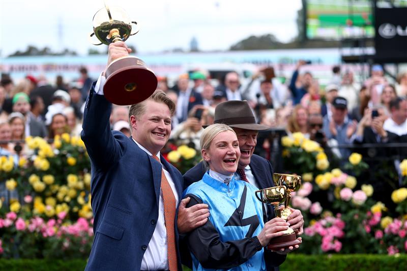MELBOURNE, AUSTRALIA - NOVEMBER 04: Jamie Melham lifts the trophy with co trainers Tony McEvoy and Calvin McEvoy after riding Half Yours to win Race 7, the Lexus Melbourne Cup  during Melbourne Cup Day at Flemington Racecourse on November 04, 2025 in Melbourne, Australia. (Photo by Josh Chadwick/Getty Images)