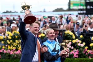 MELBOURNE, AUSTRALIA - NOVEMBER 04: Jamie Melham lifts the trophy with co trainers Tony McEvoy and Calvin McEvoy after riding Half Yours to win Race 7, the Lexus Melbourne Cup  during Melbourne Cup Day at Flemington Racecourse on November 04, 2025 in Melbourne, Australia. (Photo by Josh Chadwick/Getty Images)