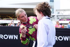 MELBOURNE, AUSTRALIA - NOVEMBER 06: Jamie Melham presents a young fan with goggles after Race Four the Good Friday Appeal Trophy during Melbourne Racing at Flemington Racecourse on November 06, 2025 in Melbourne, Australia. (Photo by Morgan Hancock/Getty Images)