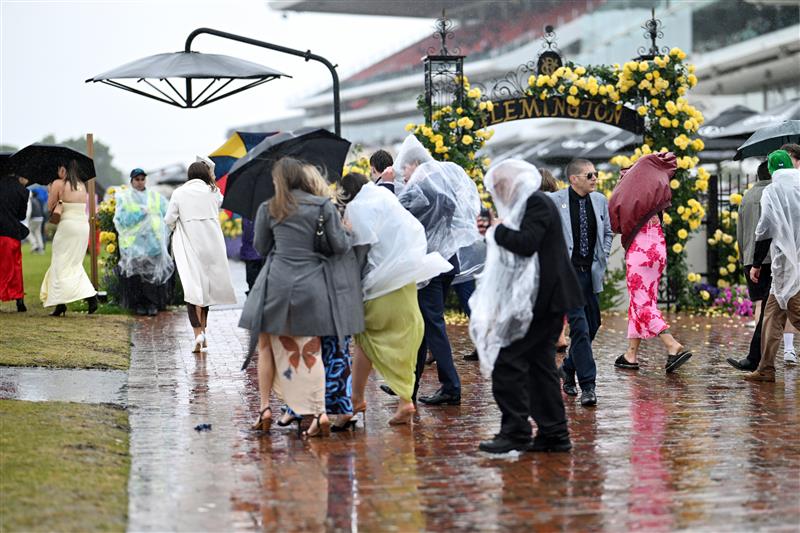 MELBOURNE, AUSTRALIA - NOVEMBER 08: A general view of racegoers in the rain during 2025 Stakes Day at Flemington Racecourse on November 08, 2025 in Melbourne, Australia. (Photo by Wendell Teodoro/Getty Images)