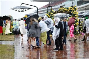 MELBOURNE, AUSTRALIA - NOVEMBER 08: A general view of racegoers in the rain during 2025 Stakes Day at Flemington Racecourse on November 08, 2025 in Melbourne, Australia. (Photo by Wendell Teodoro/Getty Images)