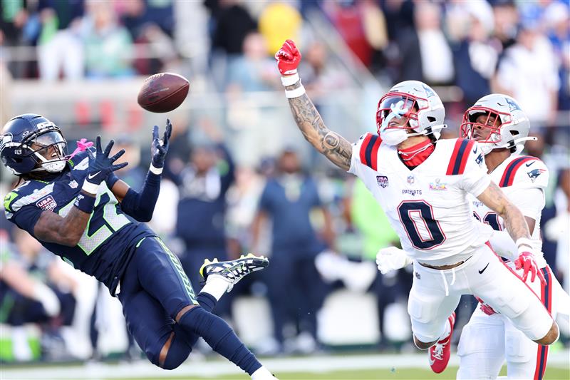 SANTA CLARA, CALIFORNIA - FEBRUARY 08: Christian Gonzalez #0 of the New England Patriots breaks up a pass intended for for Rashid Shaheed #22 of the Seattle Seahawks during the second quarter in Super Bowl LX at Levi
