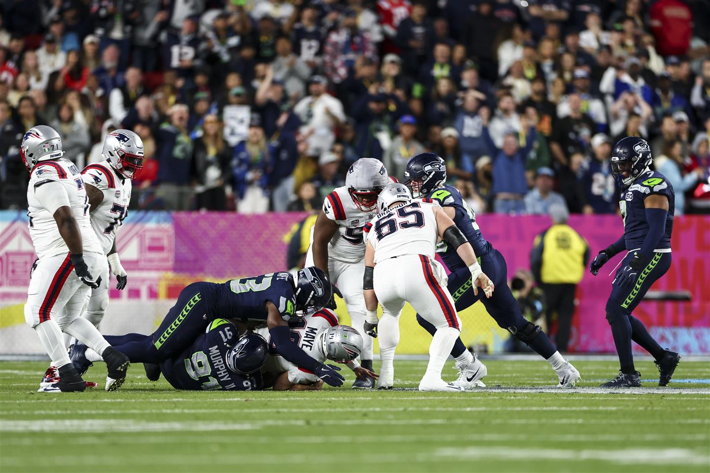 SANTA CLARA, CALIFORNIA - FEBRUARY 8: Byron Murphy II #91 of the Seattle Seahawks gets the sack on Drake Maye #10 of the New England Patriots during the third quarter of the NFL Super Bowl LX football game, at Levi