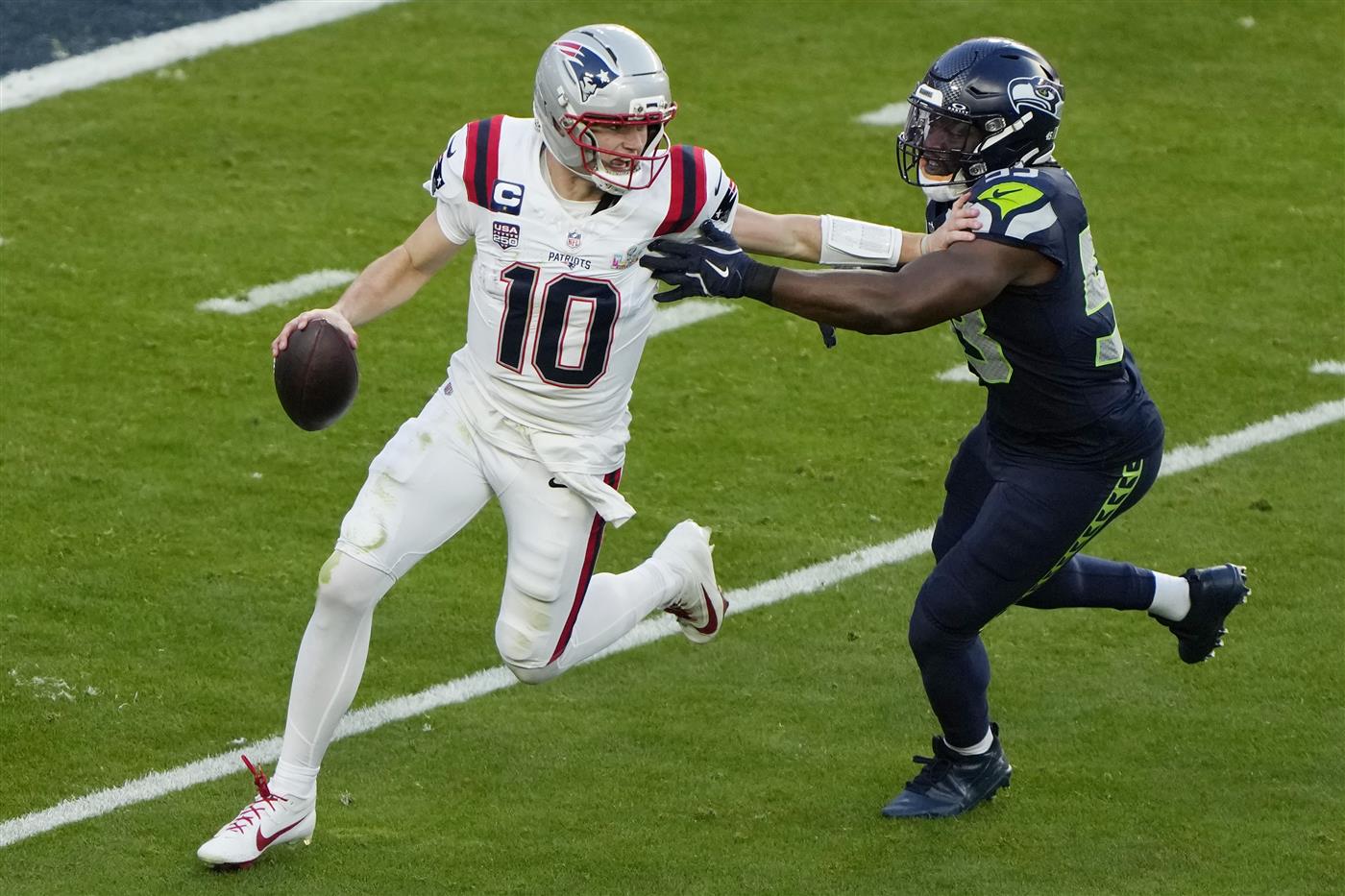 SANTA CLARA, CALIFORNIA - FEBRUARY 08: Drake Maye #10 of the New England Patriots is pressured by Boye Mafe #53 of the Seattle Seahawks during the second quarter in Super Bowl LX at Levi