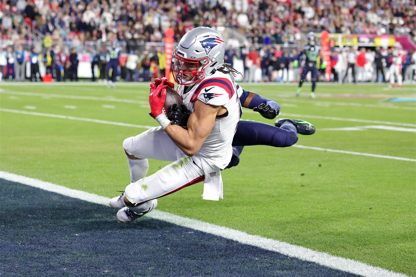 SANTA CLARA, CALIFORNIA - FEBRUARY 08: Mack Hollins #13 of the New England Patriots catches a touchdown reception against Riq Woolen #27 of the Seattle Seahawks during the fourth quarter in Super Bowl LX at Levi