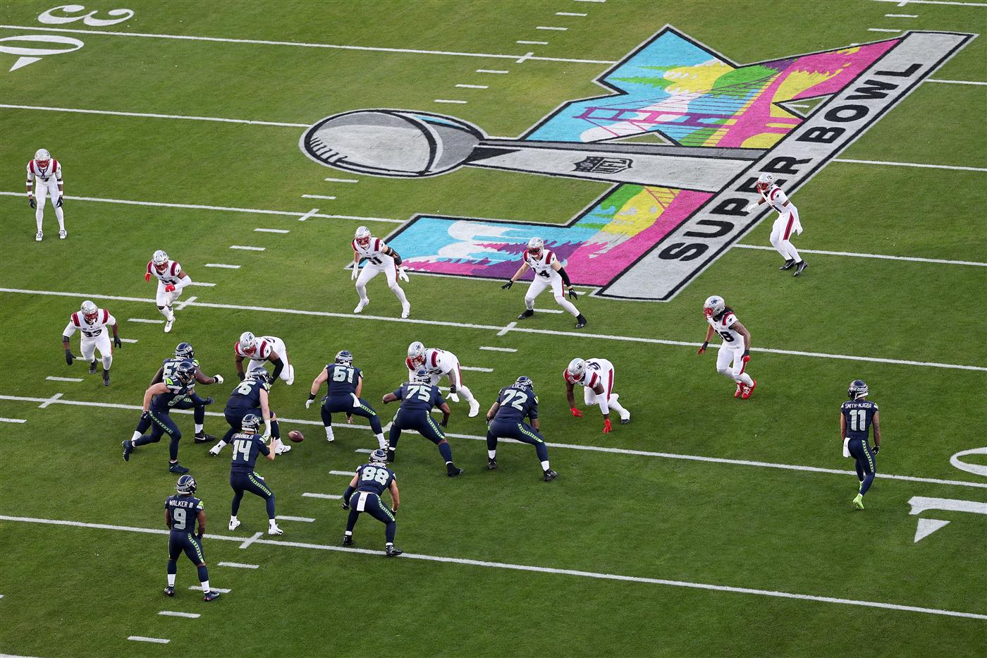 SANTA CLARA, CALIFORNIA - FEBRUARY 08: Sam Darnold #14 of the Seattle Seahawks takes the snap against the New England Patriots during the first quarter Super Bowl LX at Levi