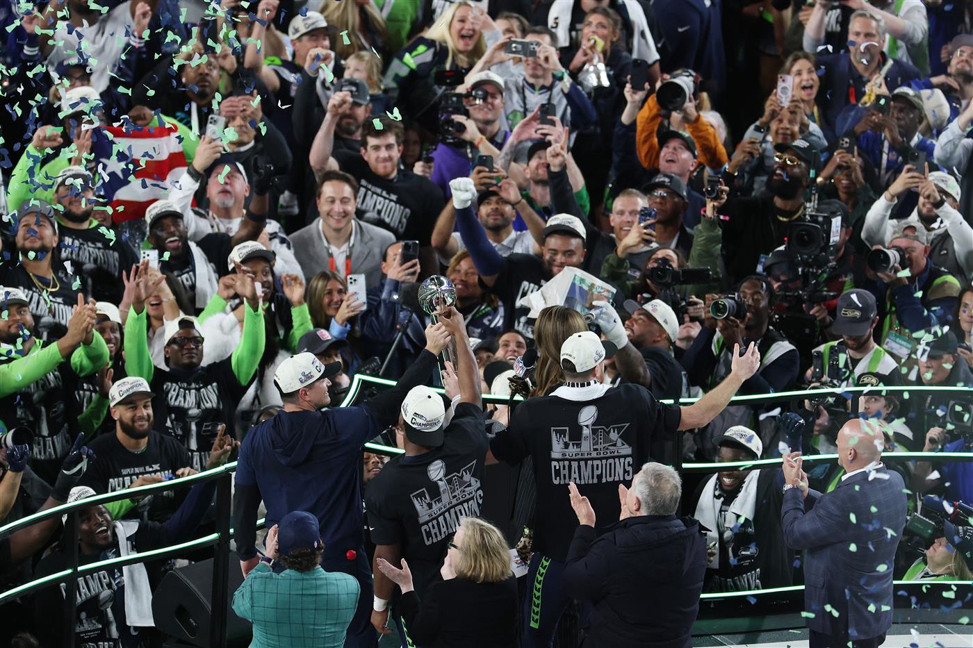 SANTA CLARA, CALIFORNIA - FEBRUARY 08: Head coach Mike MacDonald, Kenneth Walker III #9 and Sam Darnold #14 of the Seattle Seahawks celebrate with the Vince Lombardi Trophy after winning Super Bowl LX against the New England Patriots at Levi