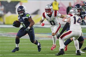 SANTA CLARA, CALIFORNIA - FEBRUARY 08: Kenneth Walker III #9 of the Seattle Seahawks rushes as Christian Gonzalez #0 of the New England Patriots pursues during the third quarter of Super Bowl LX at Levi