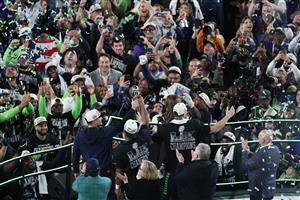 SANTA CLARA, CALIFORNIA - FEBRUARY 08: Head coach Mike MacDonald, Kenneth Walker III #9 and Sam Darnold #14 of the Seattle Seahawks celebrate with the Vince Lombardi Trophy after winning Super Bowl LX against the New England Patriots at Levi