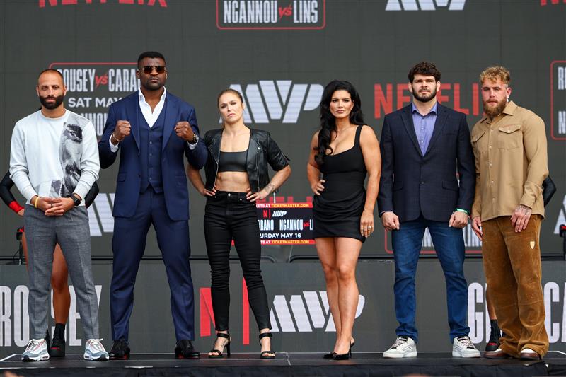 Nakisa Bidarian, Francis Ngannou, Ronda Rousey, Gina Carano, Philipe Lins, and Jake Paul pose onstage during Netflix's Ronda Rousey x Gina Carano Los Angeles MMA Press Conference at Intuit Dome on March 10, 2026 in Inglewood, California. (Getty Images for Netflix)