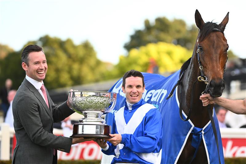 MELBOURNE, AUSTRALIA - SEPTEMBER 25: Co Trainer Adrian Bott holding the trophy with Tim Clark after Alligator Blood won Race 7, the Quayclean Underwood Stakes, during Melbourne Racing at Sandown Hillside on September 25, 2022 in Melbourne, Australia. (Photo by Vince Caligiuri/Getty Images)