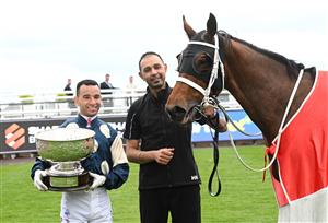 MELBOURNE, AUSTRALIA - SEPTEMBER 21: Joao Moreira poses with the trophy and strapper (r) after riding Buckaroo to wi Race 8, the Henley Homes Underwood Stakes - Betting Odds during Melbourne Racing at Caulfield Racecourse on September 21, 2024 in Melbourne, Australia. (Photo by Vince Caligiuri/Getty Images)
