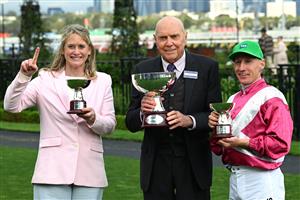 MELBOURNE, AUSTRALIA - OCTOBER 03: William Pike poses with trophy with trainer Andrea Leek (L) and owner Bob Peters after riding Cosmic Crusader to win race 8, the Tab Turnbull Stakes  during Turnbull Stakes Day at Flemington Racecourse on October 03, 2026 in Melbourne, Australia. (Photo by Vince Caligiuri/Getty Images)