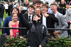 MELBOURNE, AUSTRALIA - OCTOBER 03: Craig Williams poses with young race goers during Turnbull Stakes Day at Flemington Racecourse on October 03, 2026 in Melbourne, Australia. (Photo by Vince Caligiuri/Getty Images)