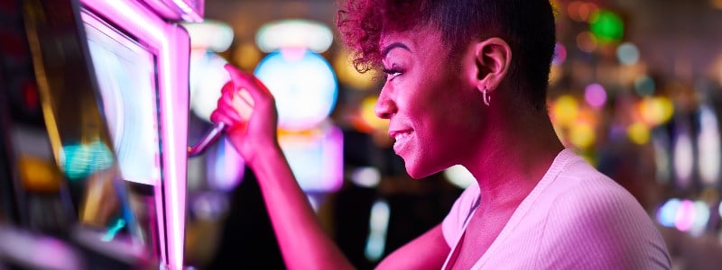 Woman playing slot machine at casino