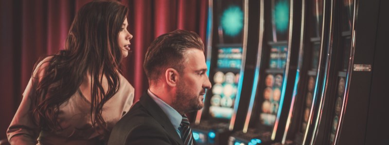 Man playing slot machine at the casino Man playing slot machine at the casino