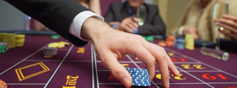 Man playing roulette chips on table