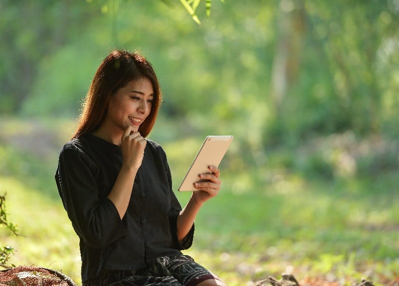 Malaysian woman playing casino on tablet Malaysian woman playing casino on tablet