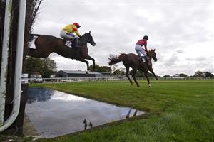 WINCANTON, ENGLAND - OCTOBER 15: Ben Poste riding Dollar And A Dream (L) clear the water jump on their way to winning The Use The racingtv.com Tracker Novices' Handicap Chase at Wincanton Racecourse on October 15, 2020 in Wincanton, England. Owners are allowed to attend if they have a runner at the meeting otherwise racing remains behind closed doors to the public due to the Coronavirus pandemic. (Photo by Alan Crowhurst/Getty Images)