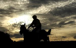 WETHERBY, ENGLAND - OCTOBER 30: Runners and riders silhouetted as they clear a fence in the Each Way Extra At bet365 Handicap Chase at Wetherby Racecourse on October 30, 2020 in Wetherby, England. (Photo by Tim Goode - Pool/Getty Images)