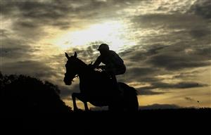 WETHERBY, ENGLAND - OCTOBER 30: Runners and riders silhouetted as they clear a fence in the Each Way Extra At bet365 Handicap Chase at Wetherby Racecourse on October 30, 2020 in Wetherby, England. (Photo by Tim Goode - Pool/Getty Images)
