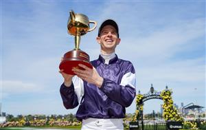 This handout photo taken and released on November 3, 2020 by Racing Photos shows Jye McNeil, who rode Twilight Payment of Ireland, celebrating with the trophy after winning the Melbourne Cup at Flemington Racecourse in Melbourne. (Photo by Scott Barbour / RACING PHOTOS / AFP) / XGTY / EDITORS NOTE ----RESTRICTED TO EDITORIAL USE MANDATORY CREDIT " AFP PHOTO /SCOTT BARBOUR / RACING PHOTOS" NO MARKETING NO ADVERTISING CAMPAIGNS - DISTRIBUTED AS A SERVICE TO CLIENTS - NO ARCHIVES (Photo by SCOTT BARBOUR/RACING PHOTOS/AFP via Getty Images)