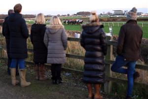WETHERBY, UNITED KINGDOM - NOVEMBER 25: Spectators outside the course grounds watch the runners and riders in the EBF Stallions Mares' Standard Open National Hunt Flat Race (GBB Race) at Wetherby Racecourse on November 25, 2020 in Wetherby, England. (Photo by Mike Egerton - Pool/Getty Images)