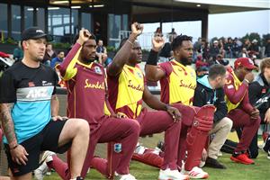 TAURANGA, NEW ZEALAND - NOVEMBER 30: New Zealand and West Indies players and staff raise their hands in support of the Black Lives Matter movement during game three of the International Twenty20 series between New Zealand and the West Indies at Bay Oval on November 30, 2020 in Tauranga, New Zealand. (Photo by Phil Walter/Getty Images)