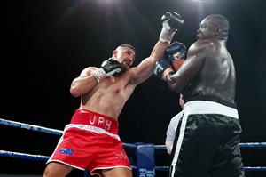 BRISBANE, AUSTRALIA - DECEMBER 03: Justis Huni punches Arsene Fosso during the Australian Heavyweight Title fight at Fortitude Music Hall on December 03, 2020 in Brisbane, Australia. (Photo by Chris Hyde/Getty Images)