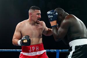 BRISBANE, AUSTRALIA - DECEMBER 03: Justis Huni punches Arsene Fosso during the Australian Heavyweight Title fight at Fortitude Music Hall on December 03, 2020 in Brisbane, Australia. (Photo by Chris Hyde/Getty Images)