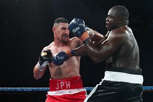 BRISBANE, AUSTRALIA - DECEMBER 03: Justis Huni punches Arsene Fosso during the Australian Heavyweight Title fight at Fortitude Music Hall on December 03, 2020 in Brisbane, Australia. (Photo by Chris Hyde/Getty Images)