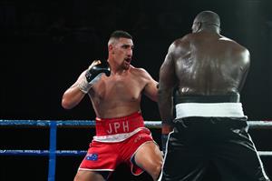 BRISBANE, AUSTRALIA - DECEMBER 03: Justis Huni punches Arsene Fosso during the Australian Heavyweight Title fight at Fortitude Music Hall on December 03, 2020 in Brisbane, Australia. (Photo by Chris Hyde/Getty Images)