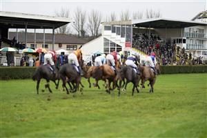 WINCANTON, ENGLAND - DECEMBER 03: A general view as runners pass the grandstands with bookmakers and the public watching on during The Watch Racing TV In Stunning HD Mares' Novices' Hurdle at Wincanton Racecourse on December 03, 2020 in Wincanton, England. Owners and a limited number of the public are allowed to attend the meeting due to the Coronavirus pandemic. (Photo by Alan Crowhurst/Getty Images)