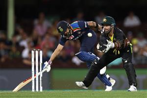 SYDNEY, AUSTRALIA - DECEMBER 06: Matthew Wade of Australia takes the ball as Virat Kohli of India stretches to make a run during game two of the Twenty20 International series between Australia and India at Sydney Cricket Ground on December 06, 2020 in Sydney, Australia. (Photo by Ryan Pierse/Getty Images)