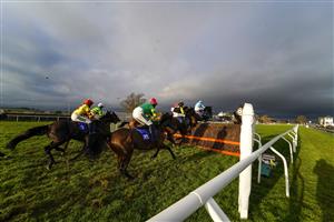 TAUNTON, ENGLAND - DECEMBER 10: A general view as runners clear the fence in front of the grandstands during The Dave Criddle Travel - Let's Travel Again Novices' Limited Handicap Chase at Taunton Racecourse on December 10, 2020 in Taunton, England. Owners and a limited number of the public are allowed to attend the meeting due to the Coronavirus pandemic. (Photo by Alan Crowhurst/Getty Images)