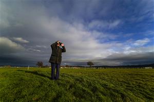 TAUNTON, ENGLAND - DECEMBER 10: A member of the public finds a small mound for a vantage point to watch the action at Taunton Racecourse on December 10, 2020 in Taunton, England. Owners and a limited number of the public are allowed to attend the meeting due to the Coronavirus pandemic. (Photo by Alan Crowhurst/Getty Images)