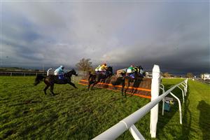 TAUNTON, ENGLAND - DECEMBER 10: A general view as runners clear the fence in front of the grandstands during The Dave Criddle Travel - Let's Travel Again Novices' Limited Handicap Chase at Taunton Racecourse on December 10, 2020 in Taunton, England. Owners and a limited number of the public are allowed to attend the meeting due to the Coronavirus pandemic. (Photo by Alan Crowhurst/Getty Images)