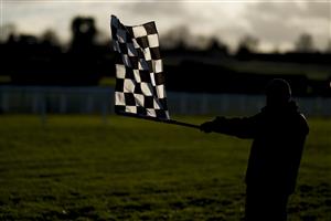 CHELTENHAM, ENGLAND - DECEMBER 12: A general view as a member of the groundstaff waves the chequered flag to show the jockeys to bypass the next hurdle at Cheltenham Racecourse on December 12, 2020 in Cheltenham, England. Owners and a limited number of the public are allowed to attend the meeting due to the Coronavirus pandemic. (Photo by Alan Crowhurst/Getty Images)