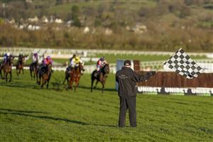CHELTENHAM, ENGLAND - DECEMBER 12: A general view as a member of the groundstaff waves the chequered flag to show the jockeys to bypass the next hurdle at Cheltenham Racecourse on December 12, 2020 in Cheltenham, England. Owners and a limited number of the public are allowed to attend the meeting due to the Coronavirus pandemic. (Photo by Alan Crowhurst/Getty Images)