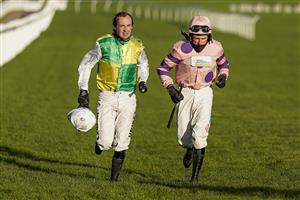 CHELTENHAM, ENGLAND - DECEMBER 12: Jockeys Nico de Boinville (L) and Harry Skelton jog back the horsewalk after being unshipped from their mounts during The Caspian Caviar Gold Cup Handicap Chase at Cheltenham Racecourse on December 12, 2020 in Cheltenham, England. Owners and a limited number of the public are allowed to attend the meeting due to the Coronavirus pandemic. (Photo by Alan Crowhurst/Getty Images)