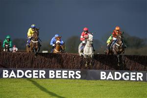 WINCANTON, ENGLAND - DECEMBER 15: A general view as dark rain clouds hover over the track as runners in The Like Racing TV On Facebook Novices' Limited Handicap Chase clear a fence at Wincanton Racecourse on December 15, 2020 in Wincanton, England. Owners and a limited number of the public are allowed to attend the meeting due to the Coronavirus pandemic. (Photo by Alan Crowhurst/Getty Images)