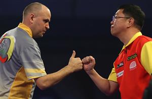 LONDON, ENGLAND - DECEMBER 18: Darius Labanauskas of Lithuania and Chengan Liu of China congratulate each other during his first round match during day four of the PDC William Hill World Darts Championship at Alexandra Palace on December 18, 2020 in London, England. (Photo by Luke Walker/Getty Images)