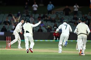ADELAIDE, AUSTRALIA - DECEMBER 17: Nathan Lyon of Australia knocks the bails off the stumps after a throw from Josh Hazlewood of Australia to dismiss Virat Kohli of India (2nd R) for 74 runs during day one of the First Test match between Australia and India at Adelaide Oval on December 17, 2020 in Adelaide, Australia. (Photo by Ryan Pierse/Getty Images)